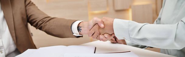 cropped shot of woman shaking hands with middle aged realtor in real estate office, deal banner - Photo, Image
