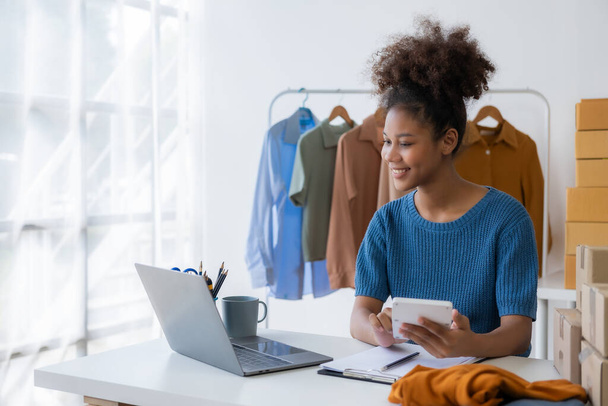 Girişim girişimcisi küçük işletme KOBİ genç kadın İnternet üzerinden kıyafet satıyor, çevrimiçi pazarlama satışları, KOBİ telefon pazarlama kavramı - Fotoğraf, Görsel