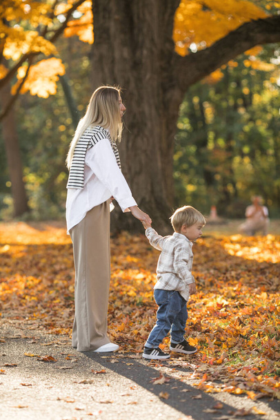 Anyák napja, szerető család. Család őszi séta a természetben a szabadban. Anya és gyermek ölelkező gyengédséggel - Fotó, kép