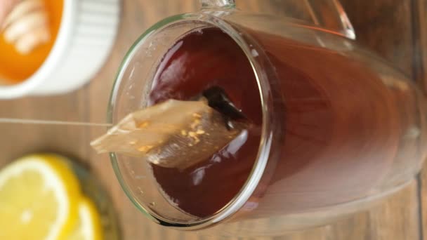 Préparation thé à partir d'un sachet de thé dans une tasse en verre - Séquence, vidéo