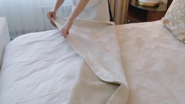 Otel odasında misafirler için yatak örtüsü hazırlarken çekilmiş bir fotoğraf. - Video, Çekim