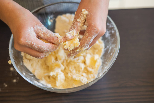Diversión culinaria creativa: Las manos de los niños Elaboración de corteza corta cruda para mini tartas - Foto, imagen