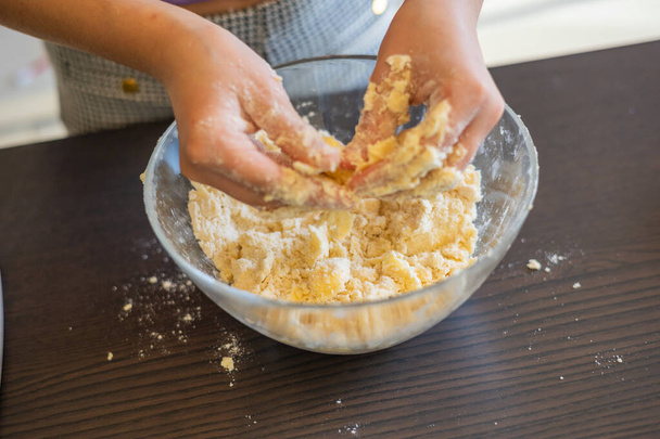 Diversión culinaria creativa: Las manos de los niños Elaboración de corteza corta cruda para mini tartas - Foto, imagen