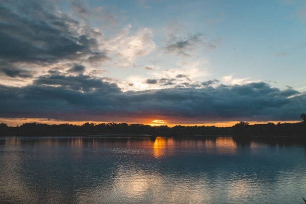 Tramonto mozzafiato sul lago Gavermeer vicino Kortrijk, Belgio meridionale. Bagliore rosso che illumina la superficie del lago e gli uccelli locali. - Foto, immagini