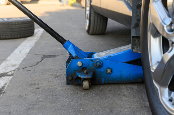 Blauer hydraulischer Bodenheber aus nächster Nähe. Reifenwechsel im Service-Center. - Foto, Bild