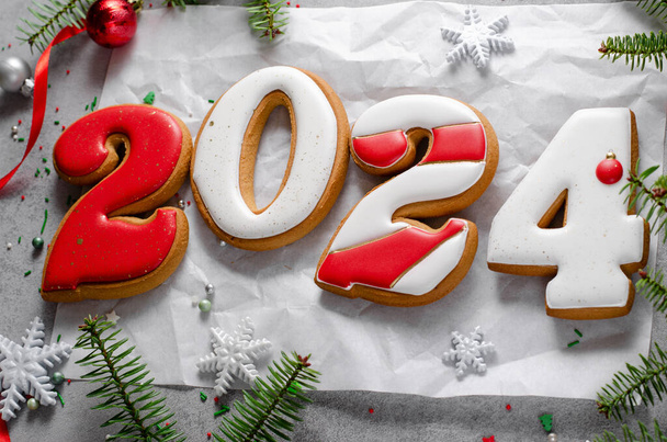 Nouvel An 2024 biscuits au pain d'épice sur fond festif lumineux, friandise de Noël faite à la main - Photo, image