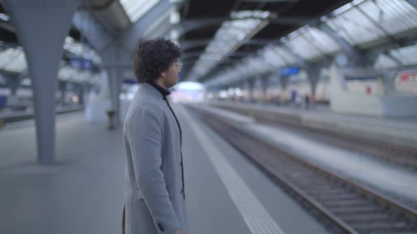 Retrato do homem indiano com óculos a comutar na estação de comboios. Imagens 4k de alta qualidade - Filmagem, Vídeo