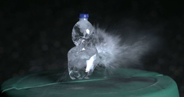 Explosión de una botella de agua de plástico en cámara súper lenta de 800 fps, capturada a alta velocidad. Objeto de disparo con bala - Foto, imagen