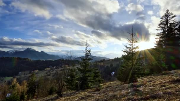Montaña paisaje montañoso con árboles y prados, puesta de sol sobre el horizonte, nubes hinchadas dramáticas., el período entre el invierno y la primavera. Imágenes de alta calidad 4k - Metraje, vídeo
