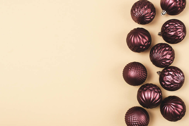 Bolas de adorno de brillo púrpura Navidad sobre fondo neutro con espacio de copia. Vista superior, plano. - Foto, imagen