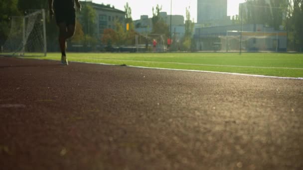 Gambe da atleta ritagliate corsa veloce sullo stadio sconosciuto sportivo afroamericano atleta corridore corsa di allenamento atletica per maratona esercizio cardio in soleggiata mattina al di fuori dello sport jogging in città - Filmati, video