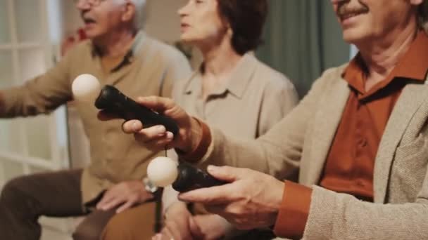 Gehakt schot van senior bedrijf tijd doorbrengen samen met videospelletjes met joystick op feest in gezellig appartement - Video