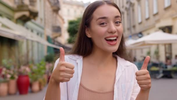 Happy caucasian woman smiling show thumb up. Enjoy happiness successful positive lady city street outside gesturing agreement young model agree winner carefree satisfied cheerful girl approval liking - Footage, Video