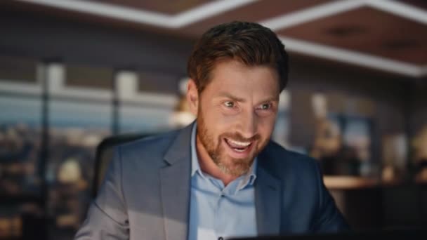 Closeup šťastný podnikatel videokonzervace na pracovišti nočních oken. Přátelský muž mává rukou a loučí se na online videokonferenci. Emocionální muž režisér končí počítačový virtuální chat uvnitř  - Záběry, video