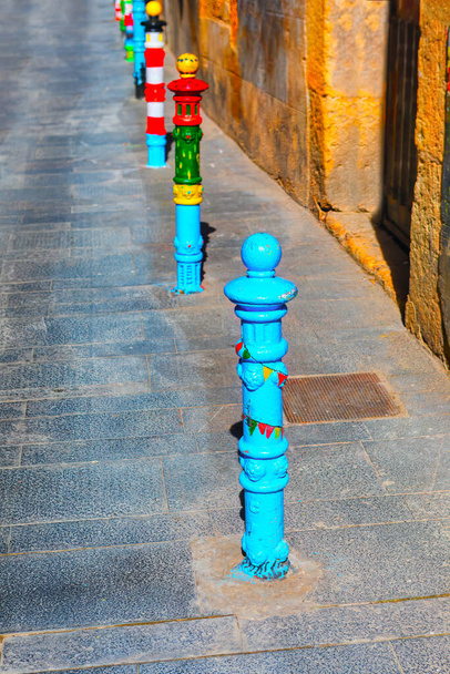 Барвисті стовпи на вулицях старого міста в Таррагоні Іспанія. Стовпи це захоплююча архітектурна особливість, яка додає дотику історії та характеру оточенню  - Фото, зображення