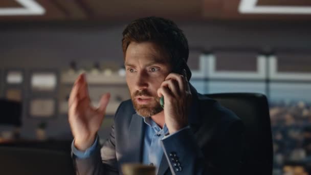 Nervous business man calling phone at dark room closeup. Annoyed office manager gesturing hands emotionally shouting smartphone. Angry boss feeling stress at work ending bad cellphone conversation - Footage, Video