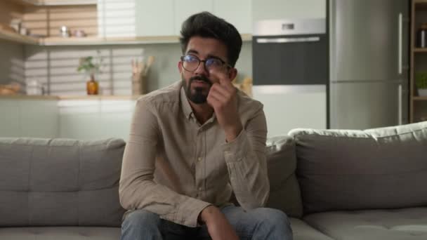 Elgondolkodtató indiai arab etnikai férfi zavaros srác otthon lakás konyha úgy gondolja, nehéz döntés megoldani kérdés boldogtalan férfi pihenés egyedül kanapén gondolkodás mély gondolatok figyelembe kétséges kérdés - Felvétel, videó