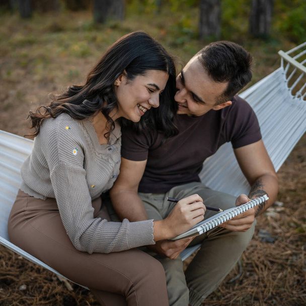 Man and woman young adult couple in nature hold and draw in nature - Photo, Image