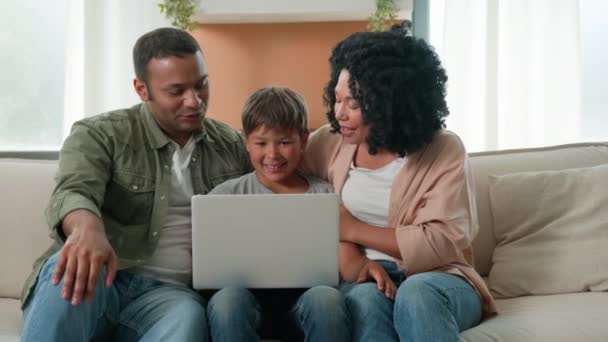 Multiraciális család afro-amerikai szülők és kaukázusi kisfiú fia gyermek beszél számítógép használata webkamera videó hívás boldog anya apa tini gyerek kommunikálni távoli csevegés online laptop eszköz otthon - Felvétel, videó