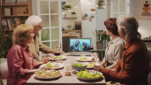 Takaisin näkymä vanhukset aikuiset puhuvat videopuhelu ystävien kanssa kannettavan tietokoneen kotona juhla - Materiaali, video