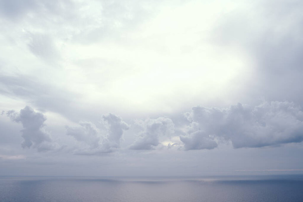 Güneş ışığı mavi denizin üzerinde fırtına bulutları arasında parlar. Yüksek kalite fotoğraf - Fotoğraf, Görsel
