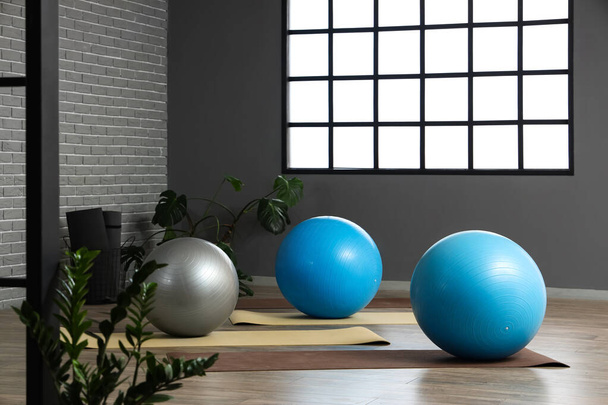 Interieur eines modernen Fitnessstudios mit Fitnessbällen und Yogamatten - Foto, Bild