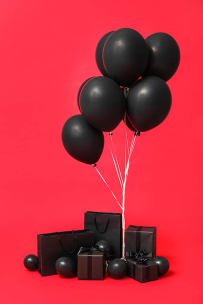 Κουτιά δώρου με μπαλόνια σε κόκκινο φόντο. Μαύρη Παρασκευή πώληση - Φωτογραφία, εικόνα