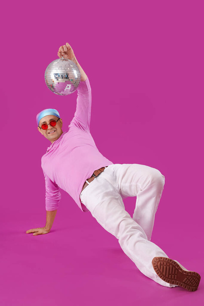 Cool starší muž s disco míč tanec na fialovém pozadí - Fotografie, Obrázek