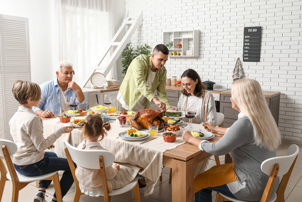 Happy family having dinner at festive table on Thanksgiving Day - Photo, Image