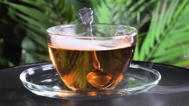 Ζεστό γλυκό τσάι σε ένα φλιτζάνι σε παλιό φόντο - Πλάνα, βίντεο