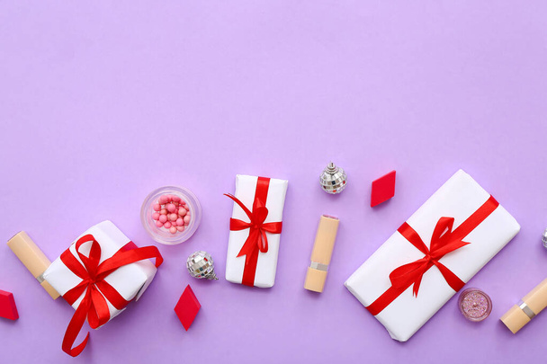 Diferentes cosméticos decorativos com bolas de Natal e caixas de presente em fundo lilás - Foto, Imagem