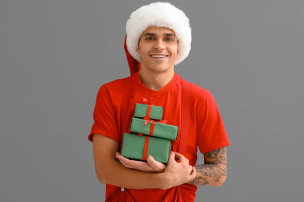Papai Noel com caixas de presente em fundo cinza - Foto, Imagem