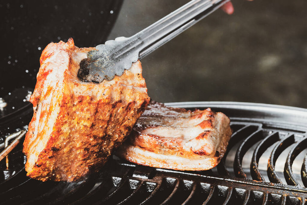 Famiglia che fa barbecue di carne di maiale croccante griglia in campeggio cena di notte - Foto, immagini