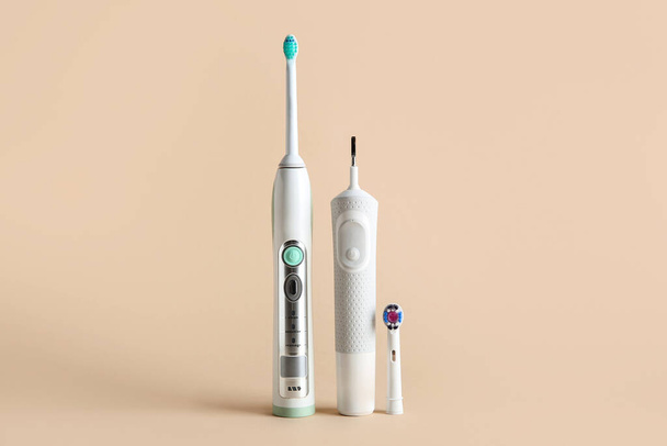 Electric toothbrushes on beige background. - Photo, Image