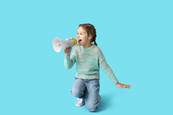 Маленькая девочка с мегафоном на синем фоне - Фото, изображение