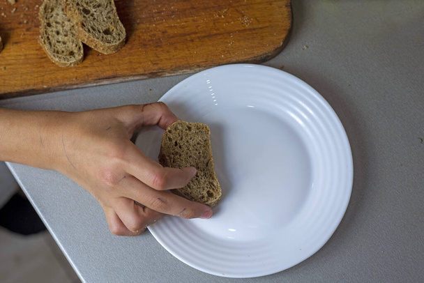 положить кусочки нарезанного хлеба на белую тарелку. flatlay - Фото, изображение