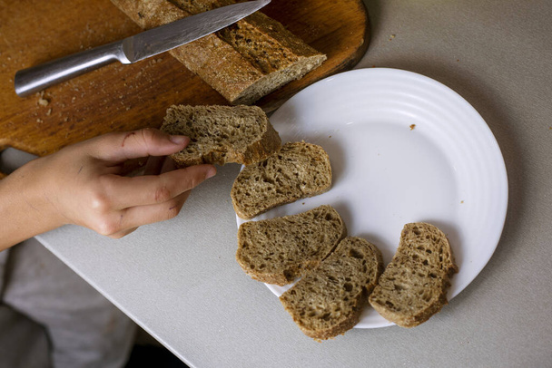 помістити шматки нарізаного хліба на білу тарілку. плоска лінія - Фото, зображення