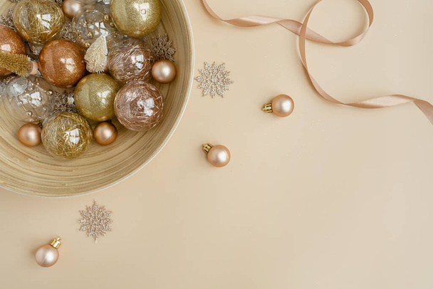 Kerstmis, nieuwjaarsvakantie compositie. Gouden kerstballen ballen, sterren op neutrale beige achtergrond. Platte lay, bovenaanzicht feestelijke mockup met lege kopieerruimte - Foto, afbeelding