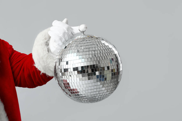 Père Noël avec boule disco sur fond gris - Photo, image