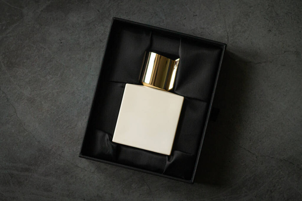 Perfume square bottle mockup in open packaging box on stone table - Photo, Image