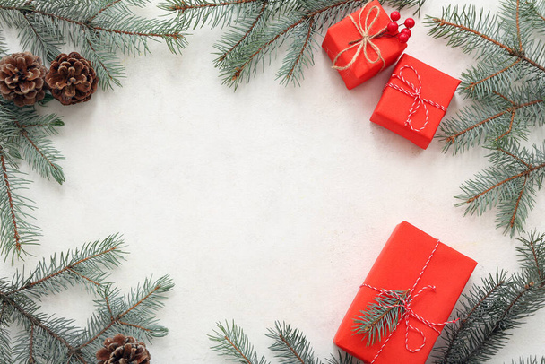 ホワイトバックグラウンドの花枝とコーンでクリスマスギフトボックスで作られたフレーム - 写真・画像