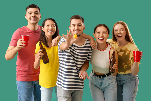 Grupo de jovens amigos com cerveja e bola no fundo verde - Foto, Imagem