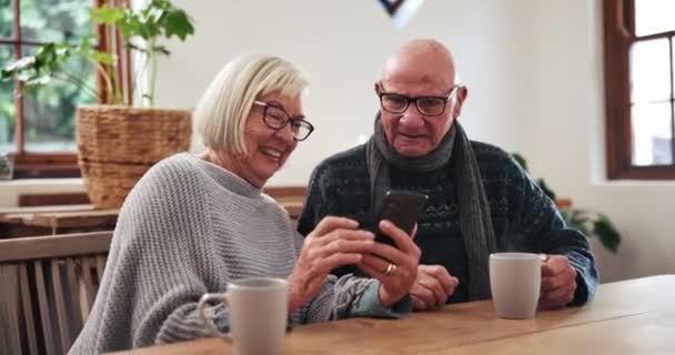 Senior, couple or phone with scroll for social media, reading news article or internet website at table in lounge. Elderly, people and smartphone or laughing for notification or online search at home. - Footage, Video