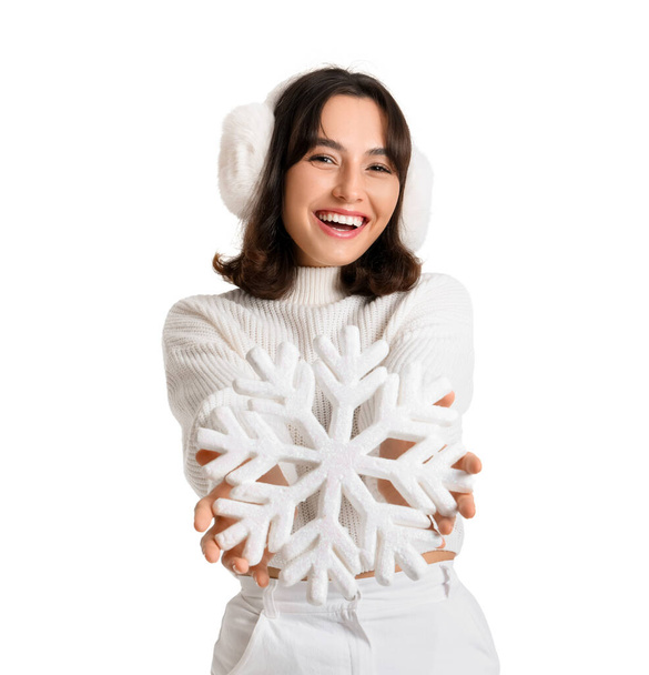 Mujer joven en suéter cálido con copo de nieve sobre fondo blanco - Foto, imagen