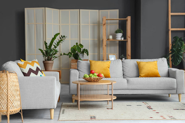 Интерьер современной гостиной с диванами и яблоками на столе - Фото, изображение