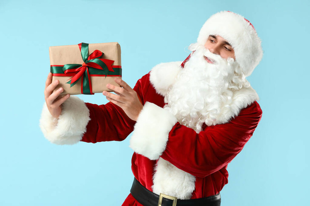 Joulupukki lahjapakkauksella sinisellä taustalla - Valokuva, kuva