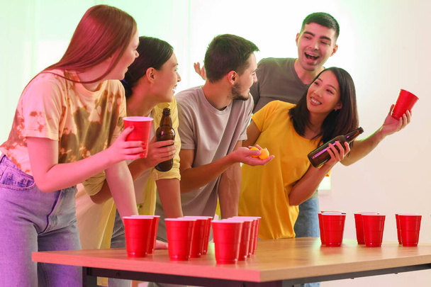 Grupo de jóvenes amigos jugando al pong de cerveza en la fiesta - Foto, Imagen