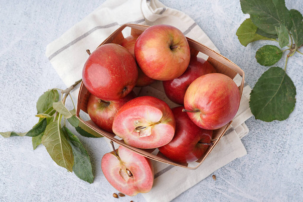 Basket with sweet pink apples and leaves on white background - Photo, Image