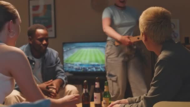 Média foto de companhia multiétnica de amigos reunidos em apartamento na noite de fim de semana, conversando, bebendo cerveja e comendo pizza - Filmagem, Vídeo