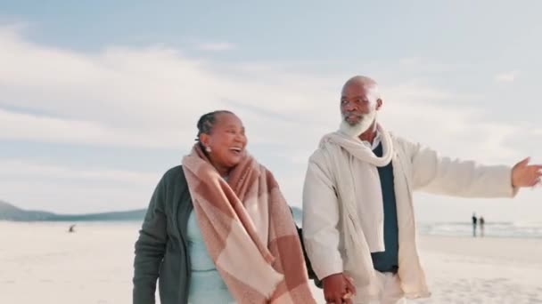 Senior, couple and pointing on beach with smile for vacation, holiday or adventure with blue sky and freedom. Black people, man or woman by sea or ocean with walking for experience, travel or happy. - Footage, Video